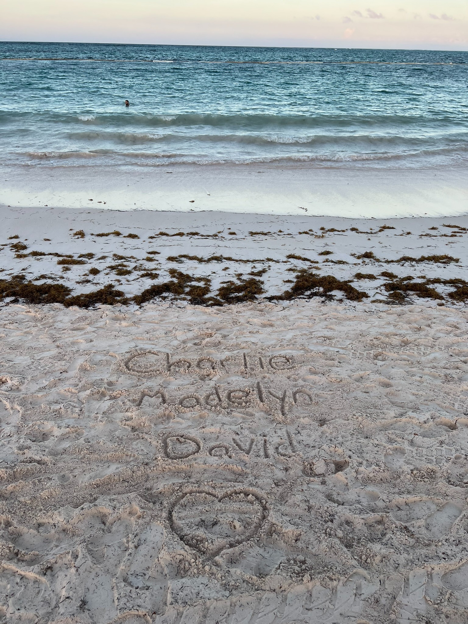 Charlie Madelyn David's name written in the sand at the beach
